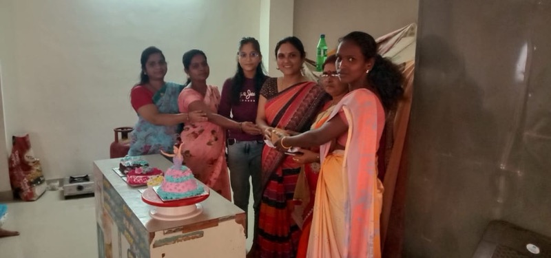 Women gathered around a table for a community celebration
