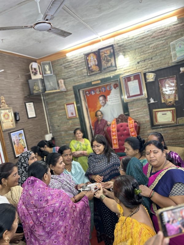 Siddhali Anup Shah meeting women at a busy indoor community gathering in Phaltan