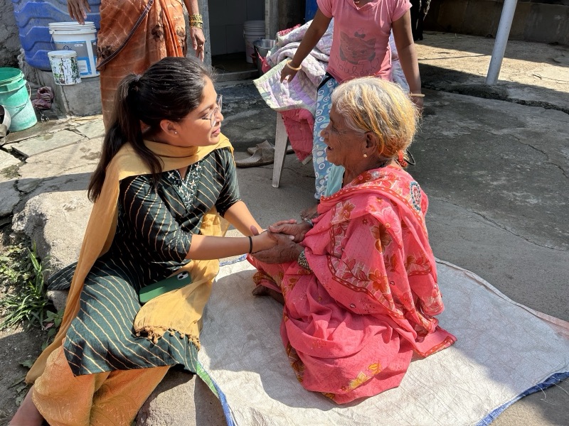 Siddhali Anup Shah greeting an elderly woman outdoors