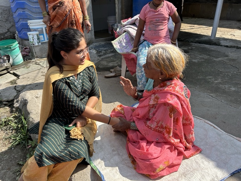 Siddhali Anup Shah listening to an elderly woman during a community visit